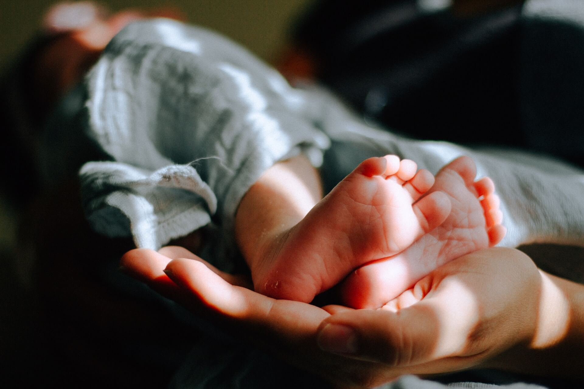 hånd holder babyfødder